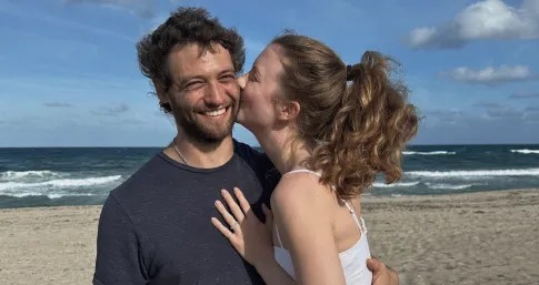  coppia-sorridente-mentre-la-donna-bacia-l'uomo-sulla-guancia-mostrando-connessione-e-felicita 